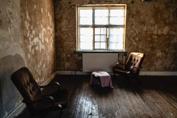 two brown armchairs beside wall